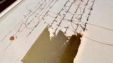 Abstract artwork with script and gold leaf.