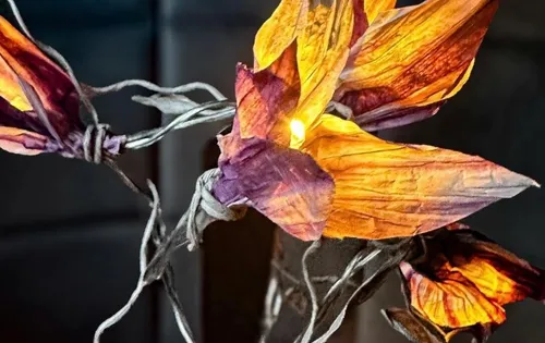 Leuchtende Blumenlampe mit verdrehten Drahtstielen.