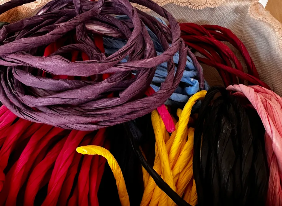 Colorful yarn bundles in woven container.