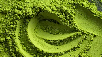 Green matcha powder swirled on a surface.