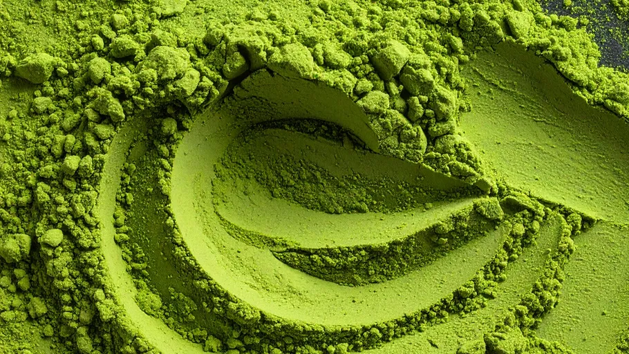 Grünes Matcha-Pulver auf einer Oberfläche verteilt.