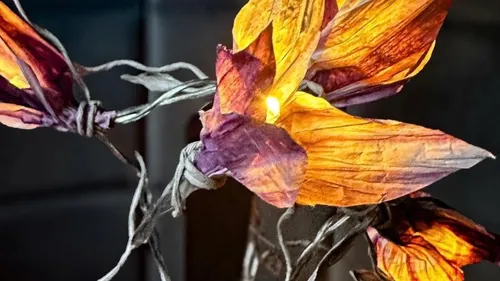 Bunte Papierblumen mit leuchtenden Lichtern.