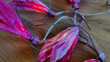 Dekorative Lichter in pinken Blattformen auf Tisch.