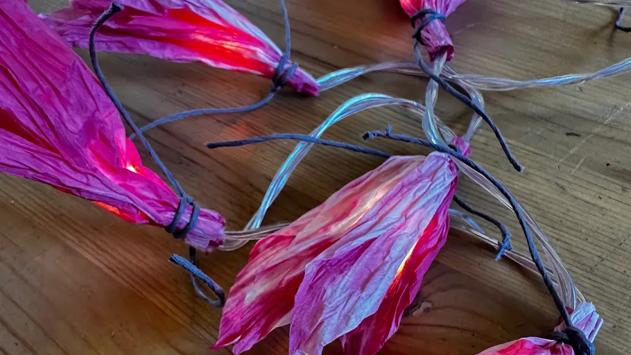 Dekorative Lichter in pinken Blattformen auf Tisch.