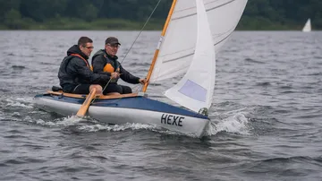 Zwei Personen segeln ein kleines Boot auf Wasser.