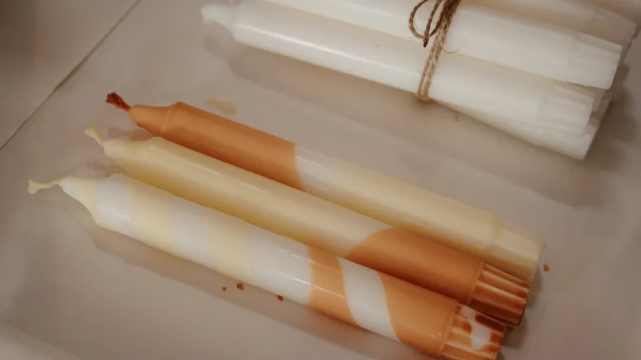 Striped candles on a beige surface.
