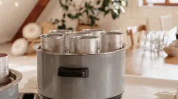 Metal pots in a kitchen on a stove.