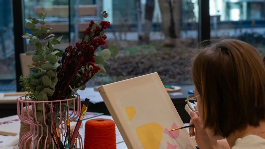 Person painting on canvas indoors.