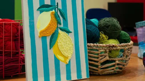 Canvas with lemons painting, surrounded by yarn.