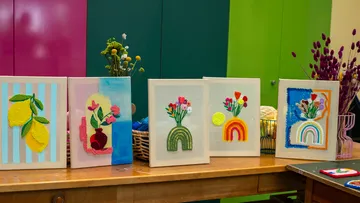 Bunte Punch-Needle-Kunstwerke auf Holztisch.