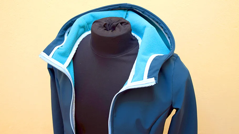 Blaue Jacke auf Schaufensterpuppe mit Kapuze oben.