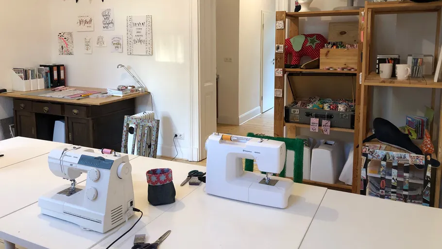 Nähmaschinen auf Arbeitstischen in einem Bastelraum.