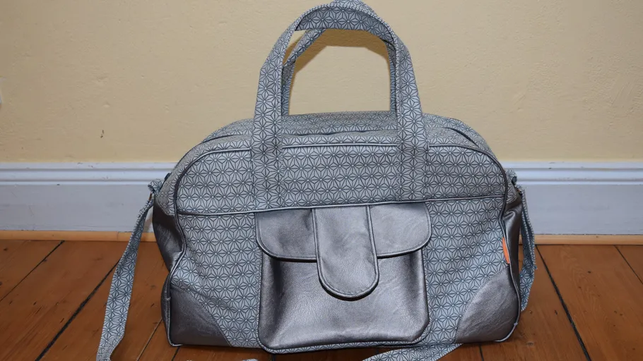 Gray patterned handbag on wooden floor.