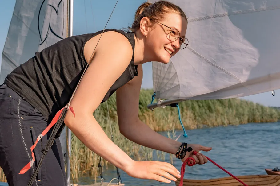 Woman smiling while sailing a boat.