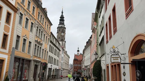 Menschen gehen eine historische europäische Straße entlang.