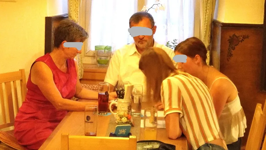 Vier Personen sitzen an einem Tisch drinnen.