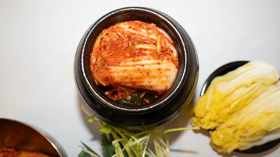 Kimchi in einem schwarzen Topf auf einem Tisch.