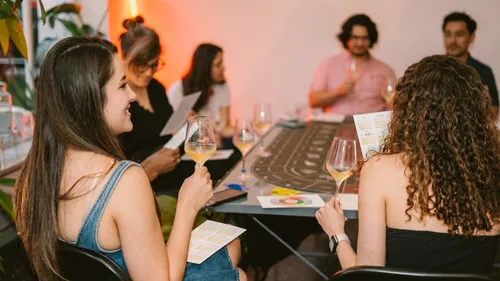 Personen am Tisch beim Weinprobieren und Lesen von Broschüren.
