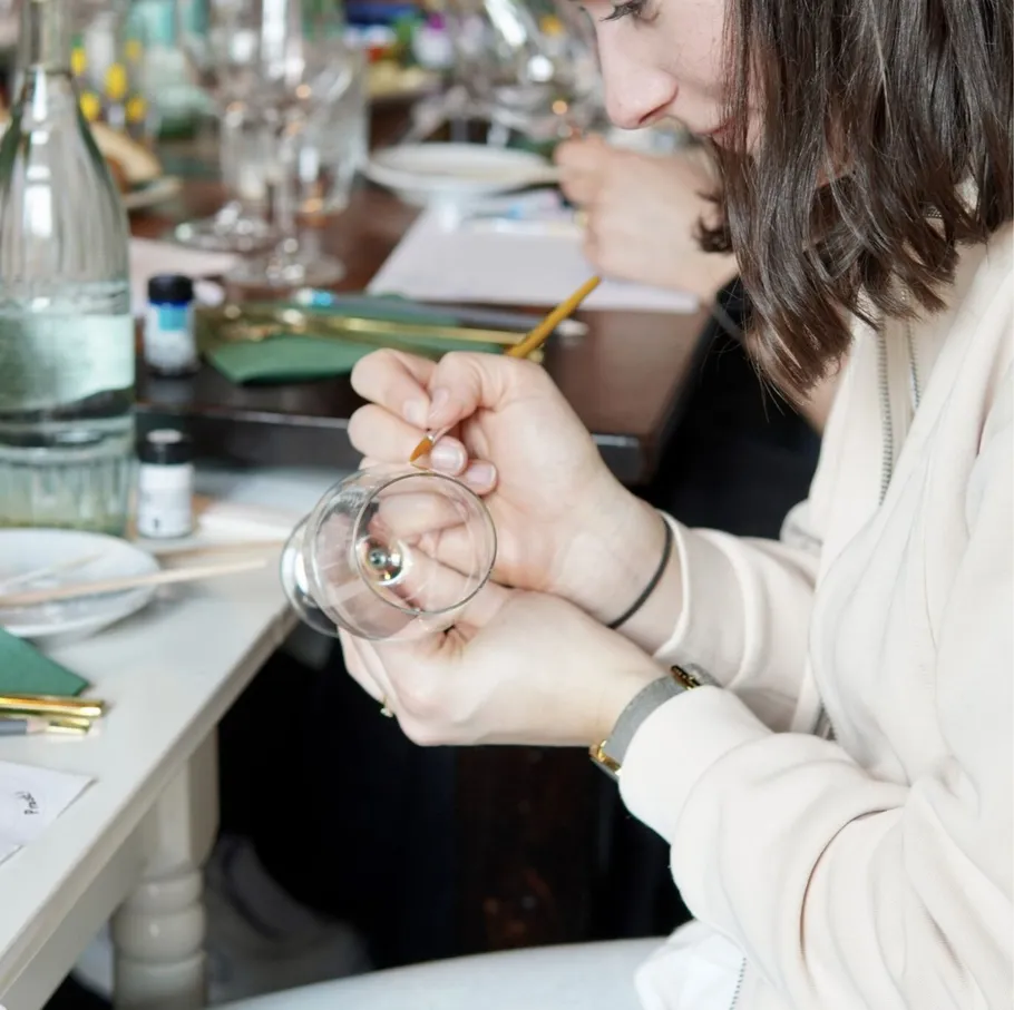Frau bemalt Glas in einem Workshop.