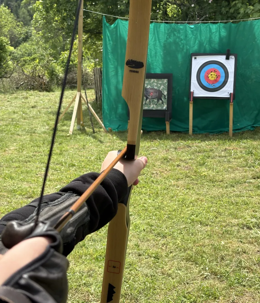 Bogenschütze zielt auf Ziel im Freien.