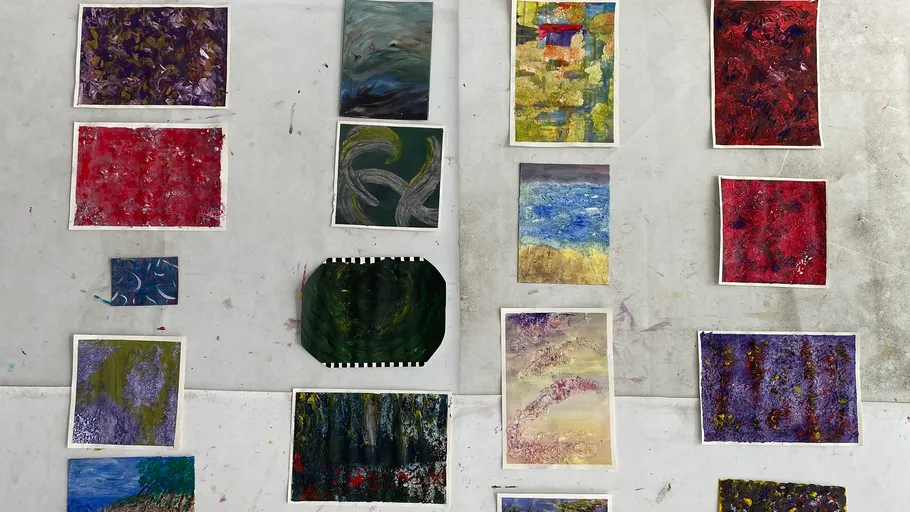 Various abstract paintings displayed on a table.