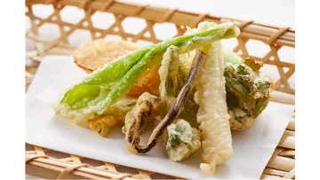 Tempura-Gemüse auf einem Flechtkorb.