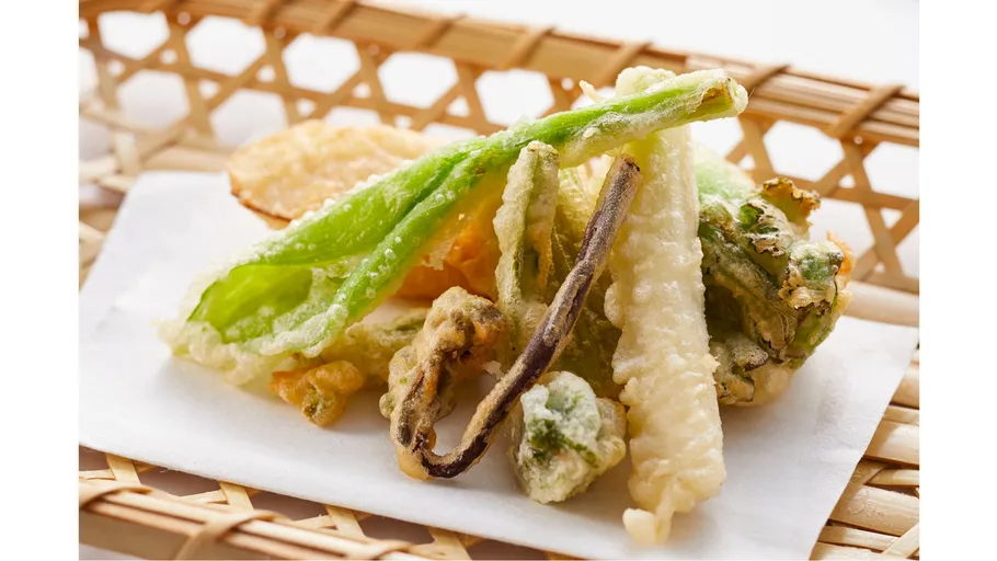 Tempura-Gemüse auf einem Flechtkorb.