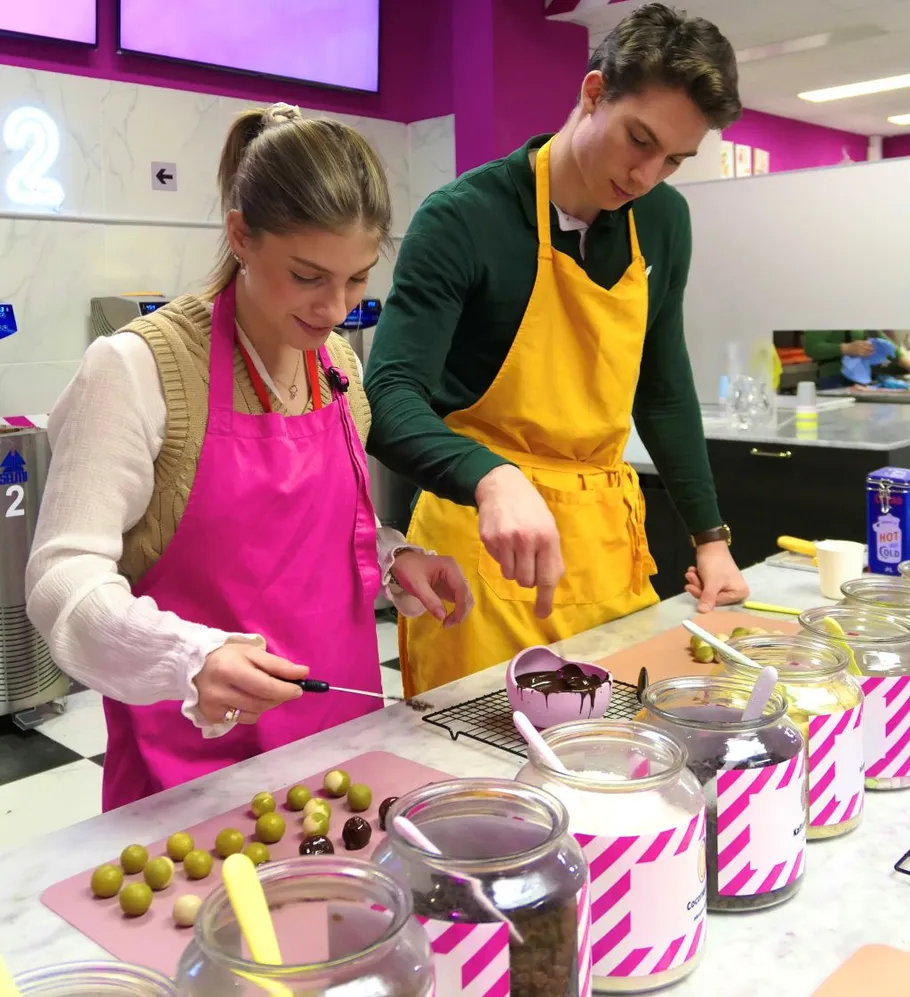 Two people making chocolates in a kitchen.