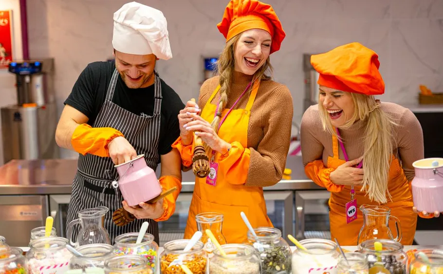 Three people in chef outfits laughing together.
