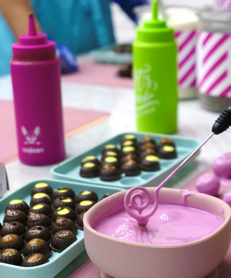 Chocolate molds with pink icing in kitchen.
