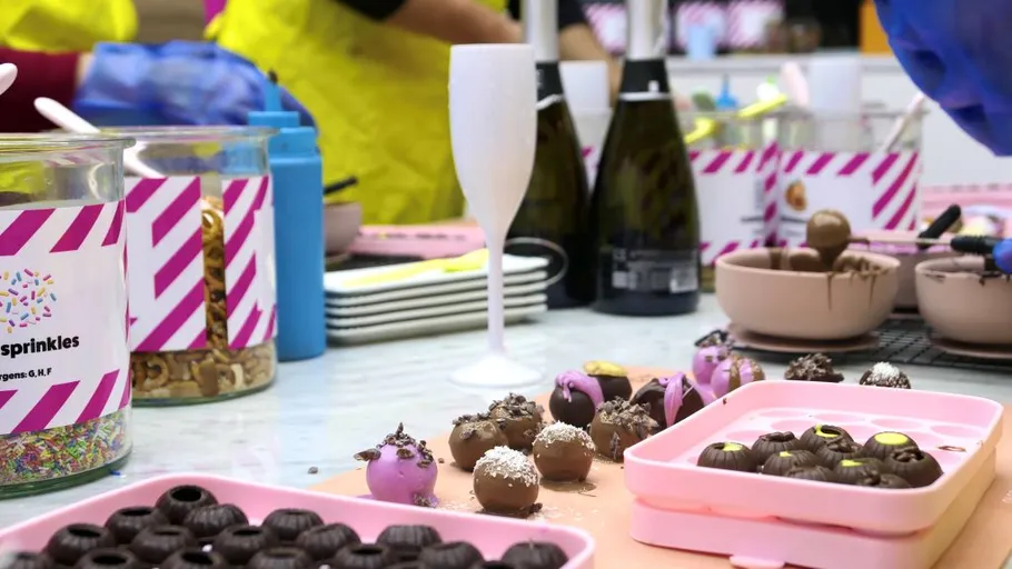 Chocolate truffles being made in a kitchen.