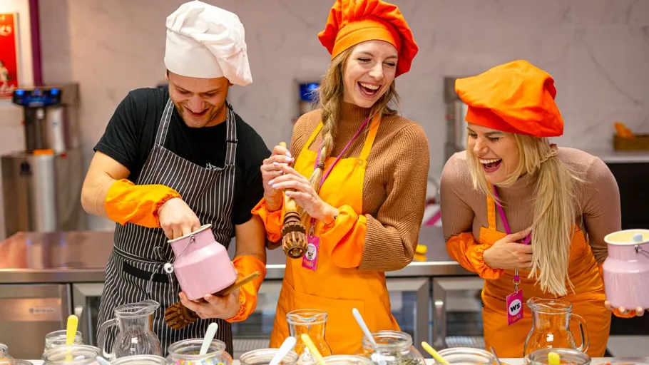 Three people in chef hats enjoying cooking together.