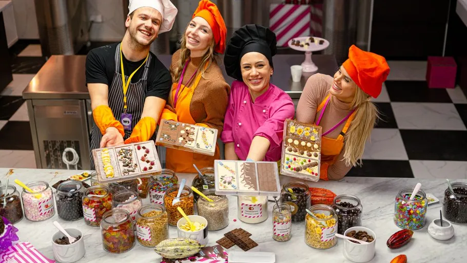 Four people displaying handmade chocolate bars.