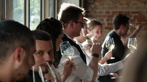 People enjoying wine in a sunlit room.