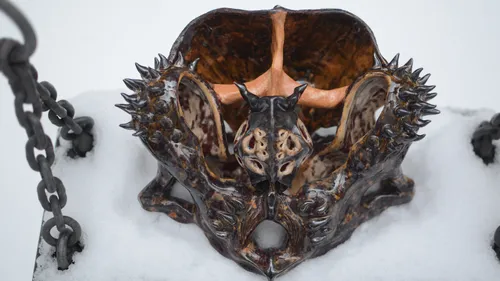Stacheliger Keramikhelm liegt auf Schnee.