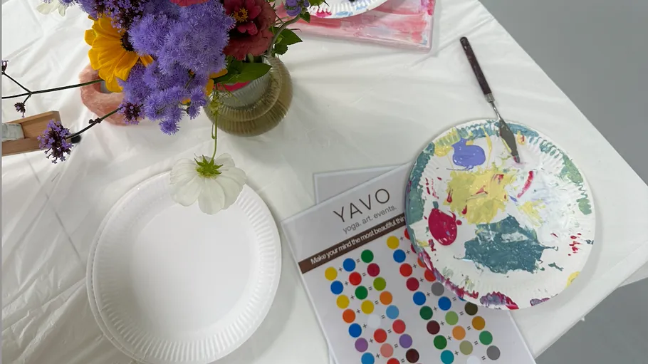 Paint supplies on table with flowers.