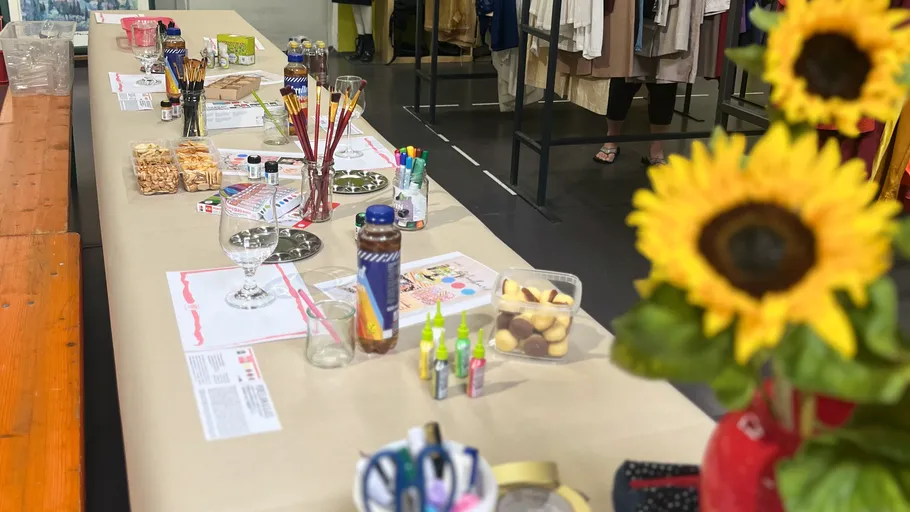 Art supplies arranged on a long table indoors.