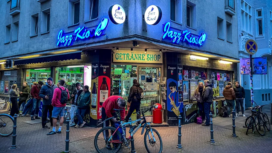 Menschen versammeln sich vor Jazz Kiosk in Stadtstraße.