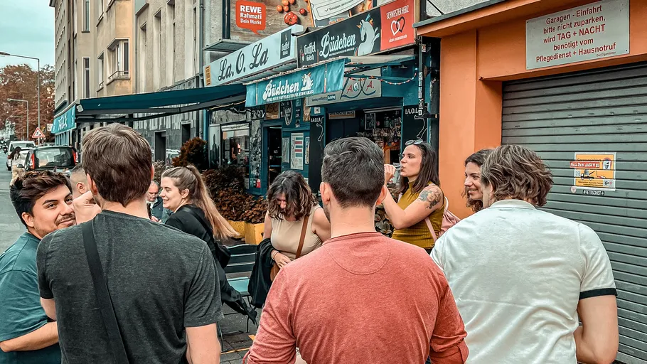 Group socializing outside a small convenience store.
