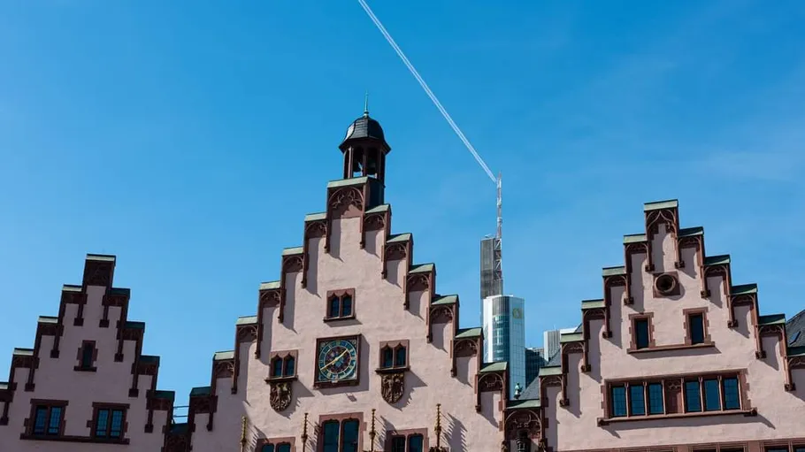 Historisches Gebäude mit Flugzeug am Himmel.