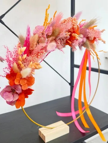 Floral wreath with pink and orange decorations.