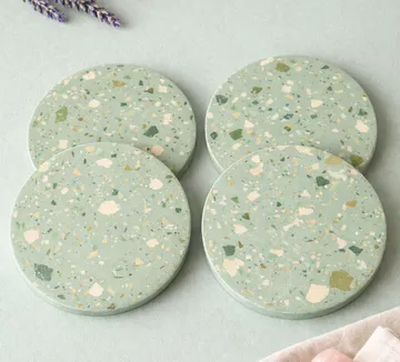 Four terrazzo coasters on a light background.
