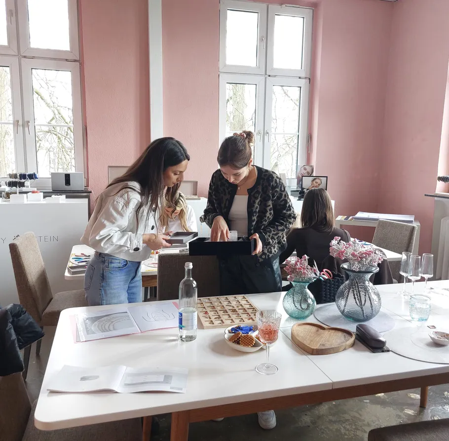 Two women examining items in a bright room.