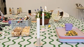 Craft table with candles, snacks, and embroidery.