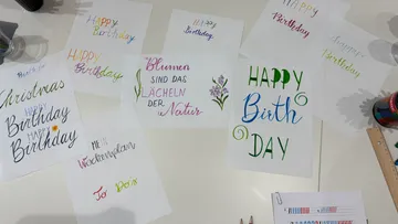 Verschiedene bunte handgeschriebene Grußkarten auf Tisch.