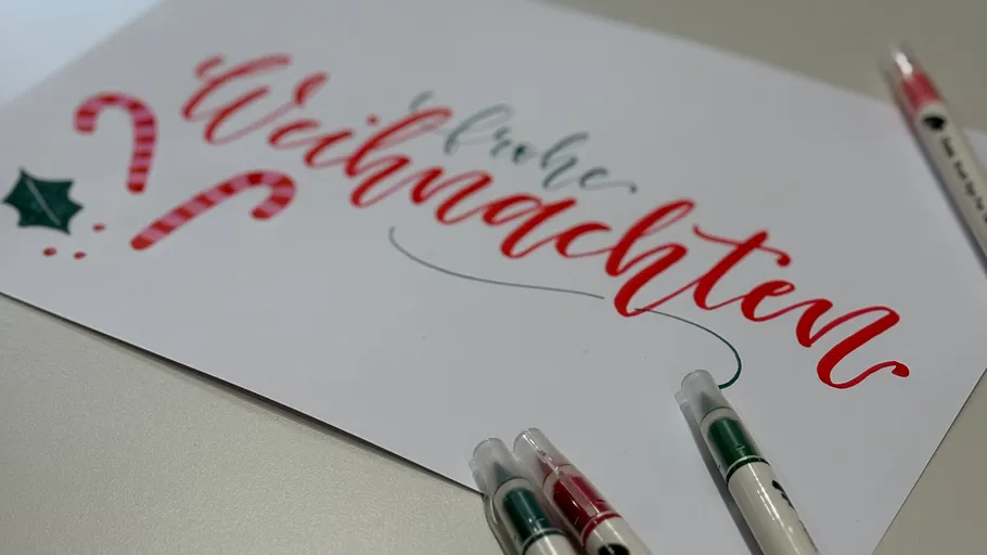 Handgeschriebene 'Frohe Weihnachten'-Karte mit Stiften.