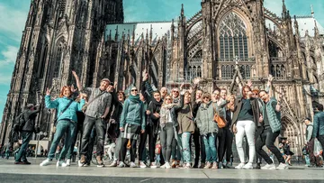 Gruppe von Menschen posiert vor Kathedrale.
