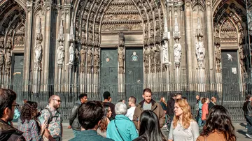 People gathered outside a gothic cathedral entrance.