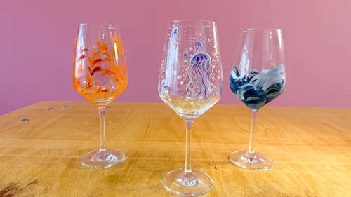 Bemalte Weingläser auf Holztisch.