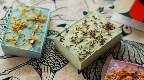 Decorative soaps with dried herbs on patterned cloth.